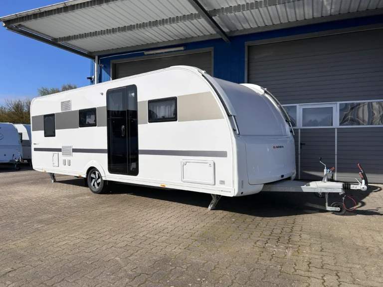 Moderne Adria Alpina campingvogn i hvid med stort panoramavindue og elegant design fotograferet hos tysk campingforhandler tæt på den dansk-tyske grænse.