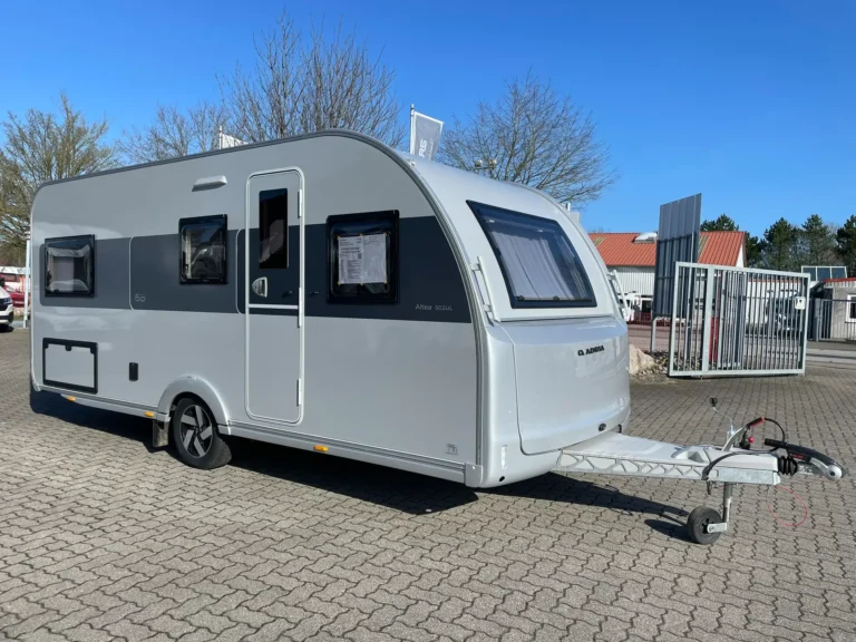 Adria Altea 502 UL campingvogn i hvid med moderne front og enkeltsenge set fra siden hos tysk campingforhandler nær den dansk-tyske grænse.